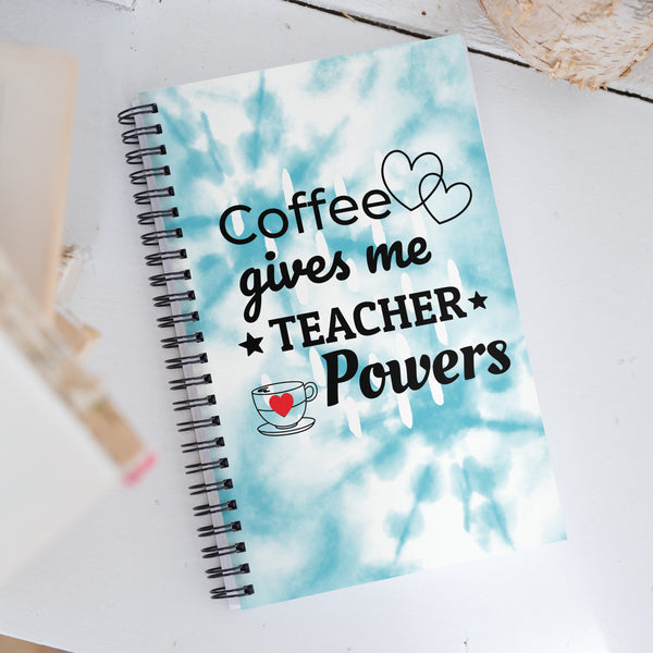 Coffee gives me Teacher Powers notebook with tie dye. Spiral notebook laying on the desk