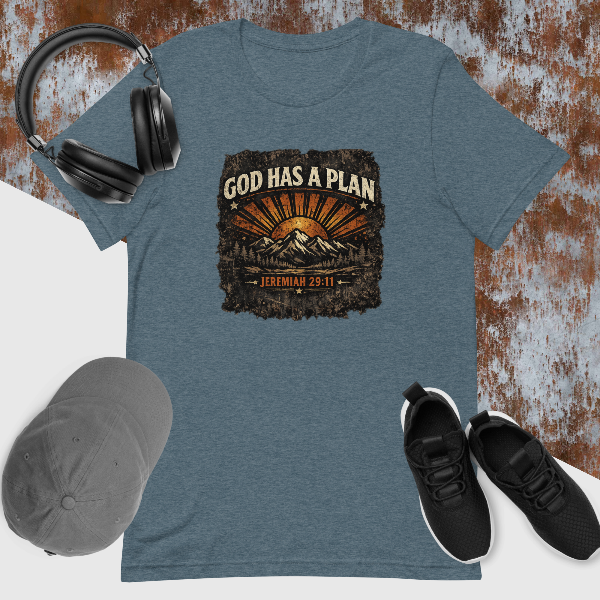 Blue t-shirt with 'God Has a Plan' graphic, headphones, cap, and shoes on a textured background
