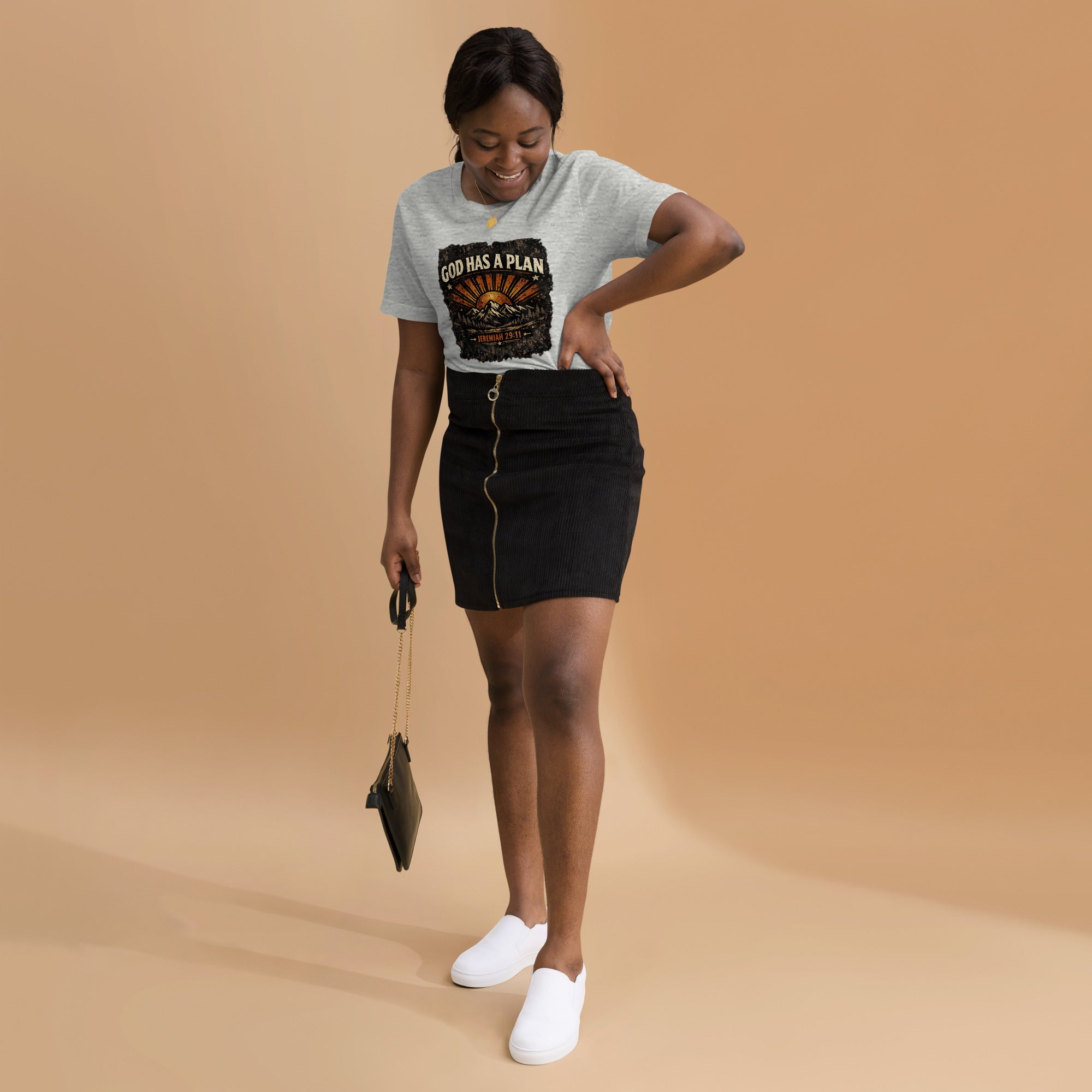 Woman wearing a t-shirt with a God Has A Plan graphic design on a beige background