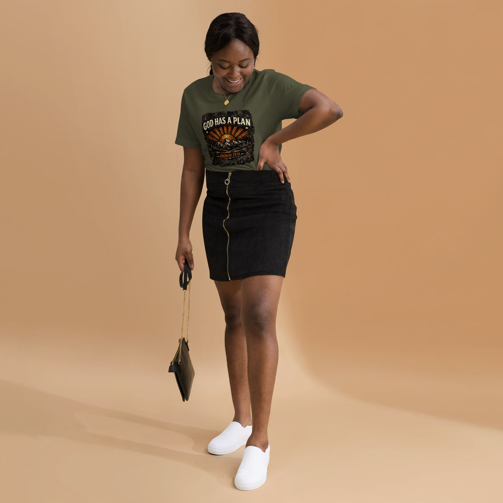 Woman wearing a green t-shirt with 'God Has A Plan' text, black skirt, and white shoes on a beige background